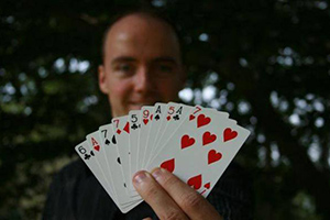 Magician Jim Munsey holds up playing cards displaying his phone number